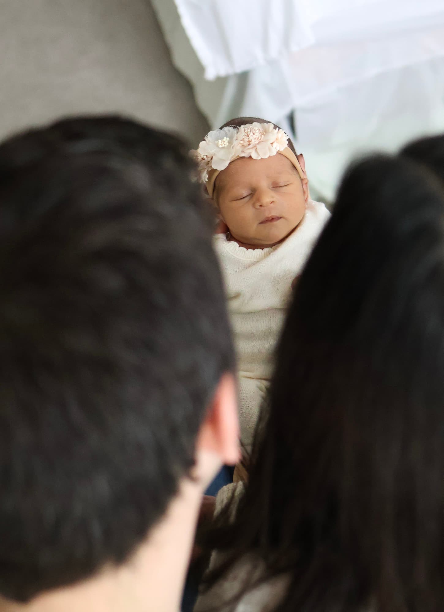 Parents looking at baby between them — newborn family moment