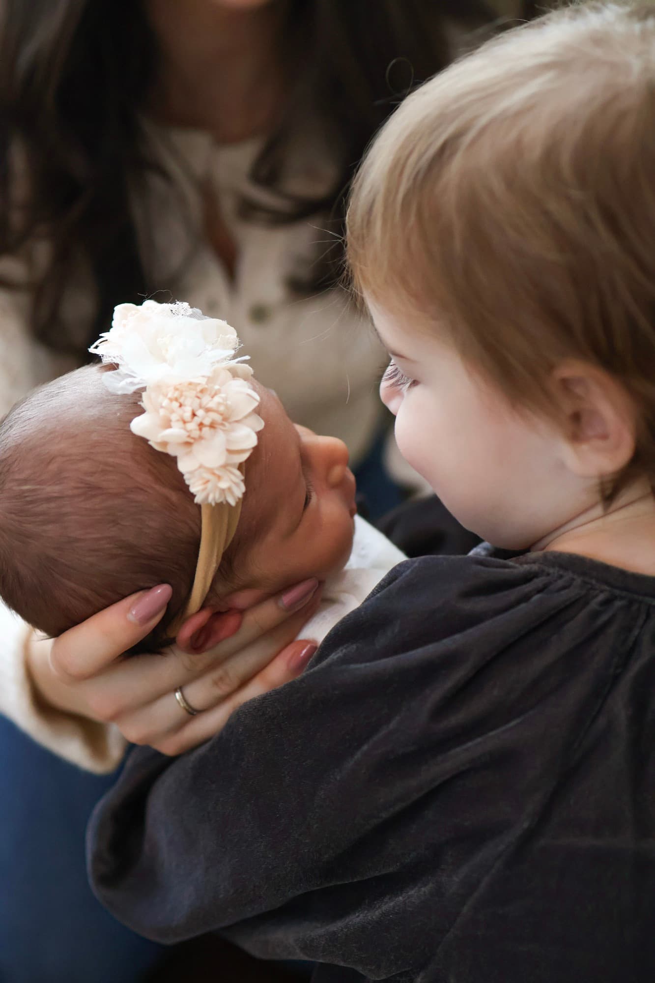 Toddler sister meeting newborn baby — sibling first moments