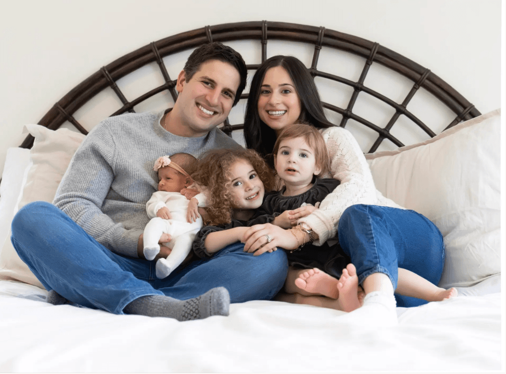 Skokie in-home family photographer — family portrait on bed with newborn and kids