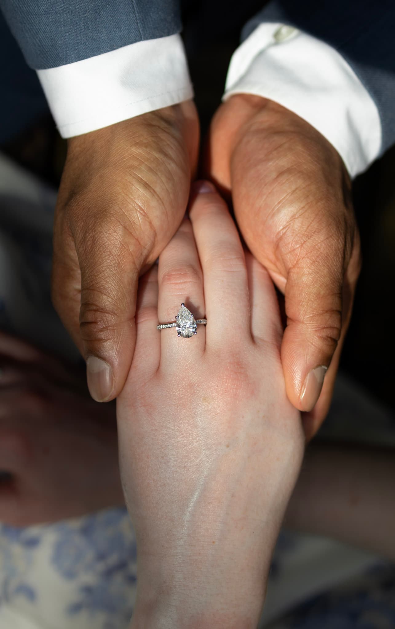 Close-up engagement ring photo held between the couple's hands at Garfield Park Conservatory