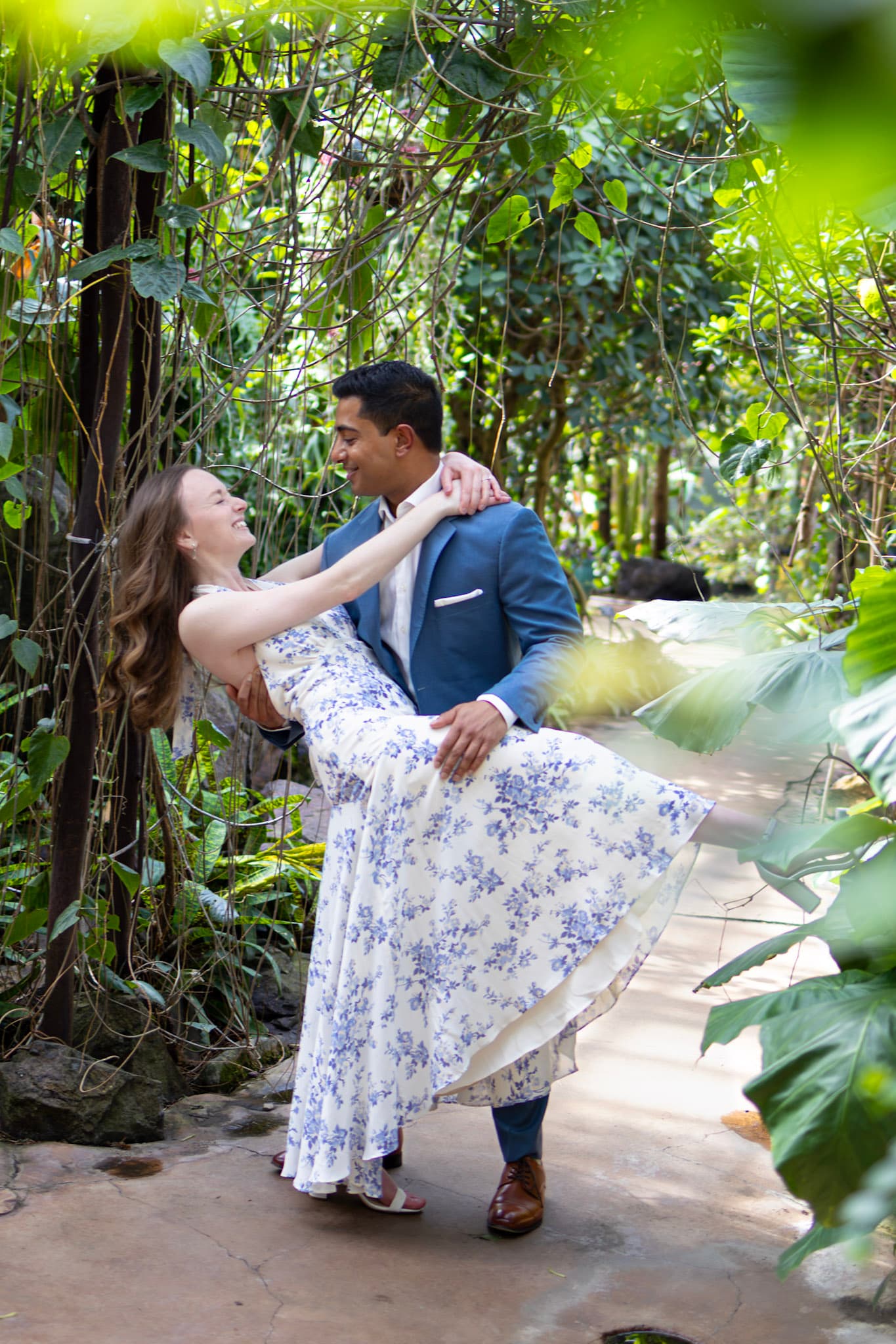 Romantic engagement portrait of couple dancing beneath vines at Garfield Park Conservatory