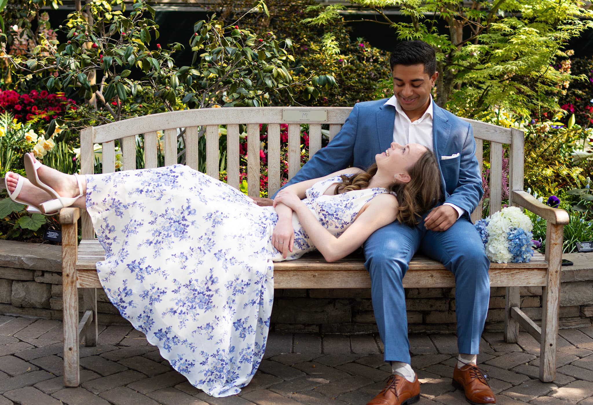 Engaged couple relaxing on a garden bench with bouquet at Garfield Park Conservatory