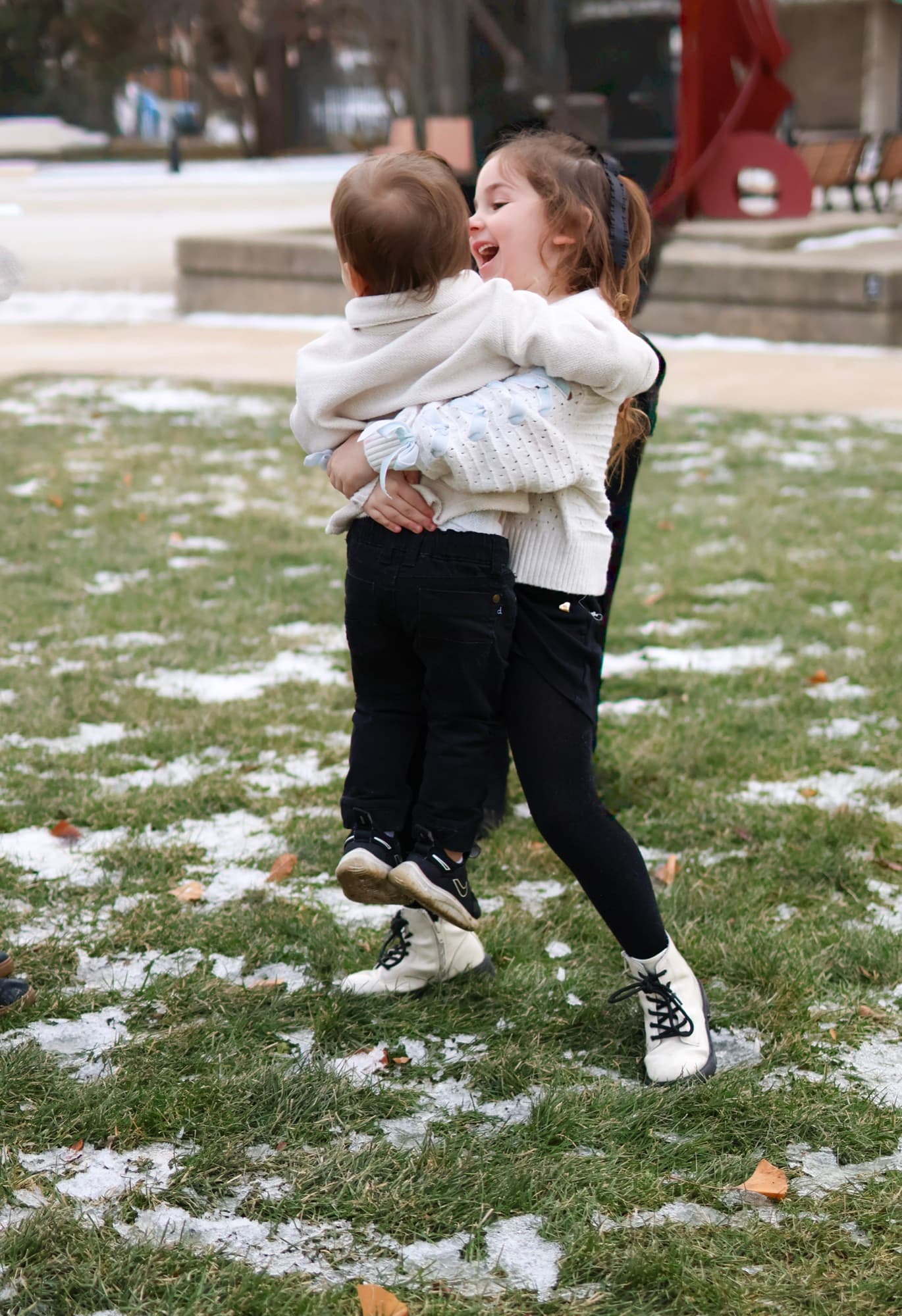 Big sister carrying baby brother outside the library — sibling photography