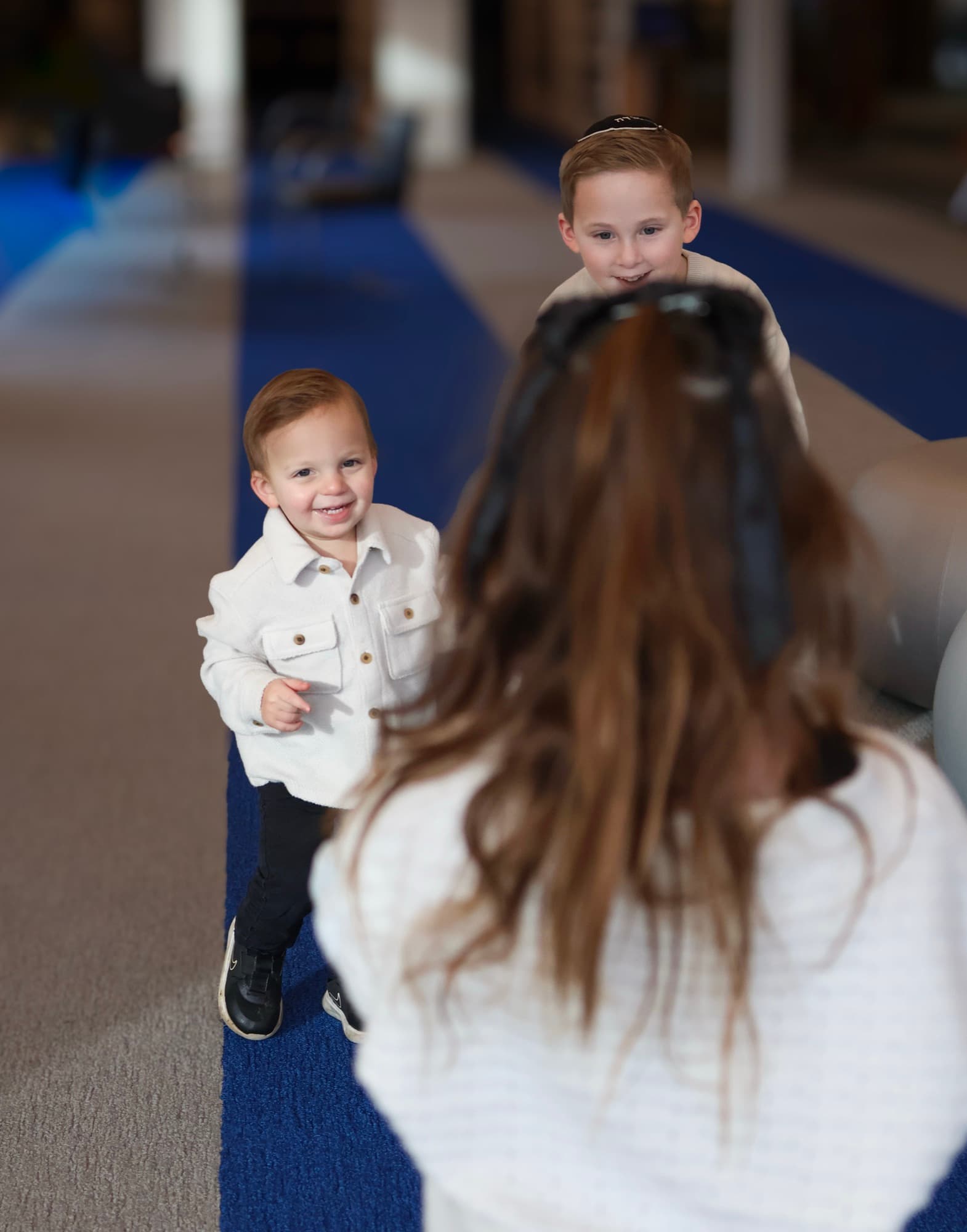 Two brothers smiling at sister in library — candid sibling moment