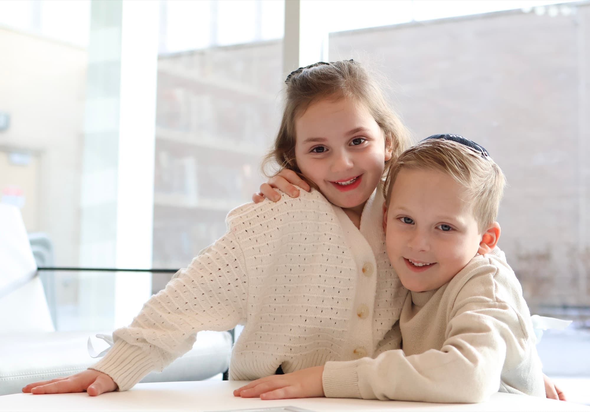 Sister and brother portrait by window — natural light sibling photography