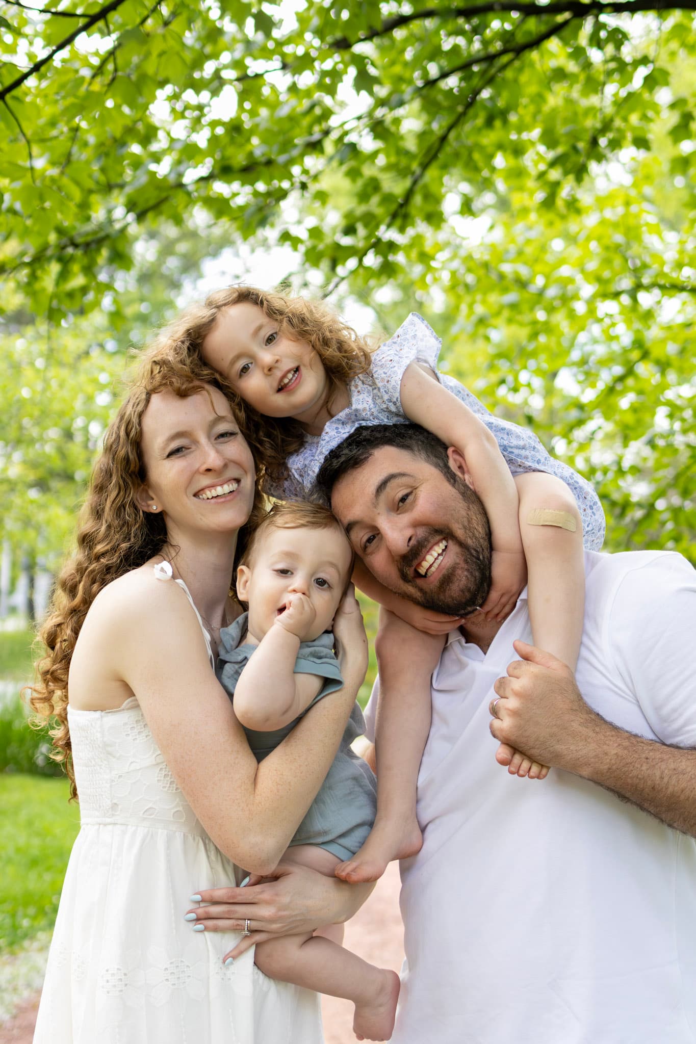 Wilmette family photographer at Keay Nature Center — family of four cheek to cheek under green canopy in summer light