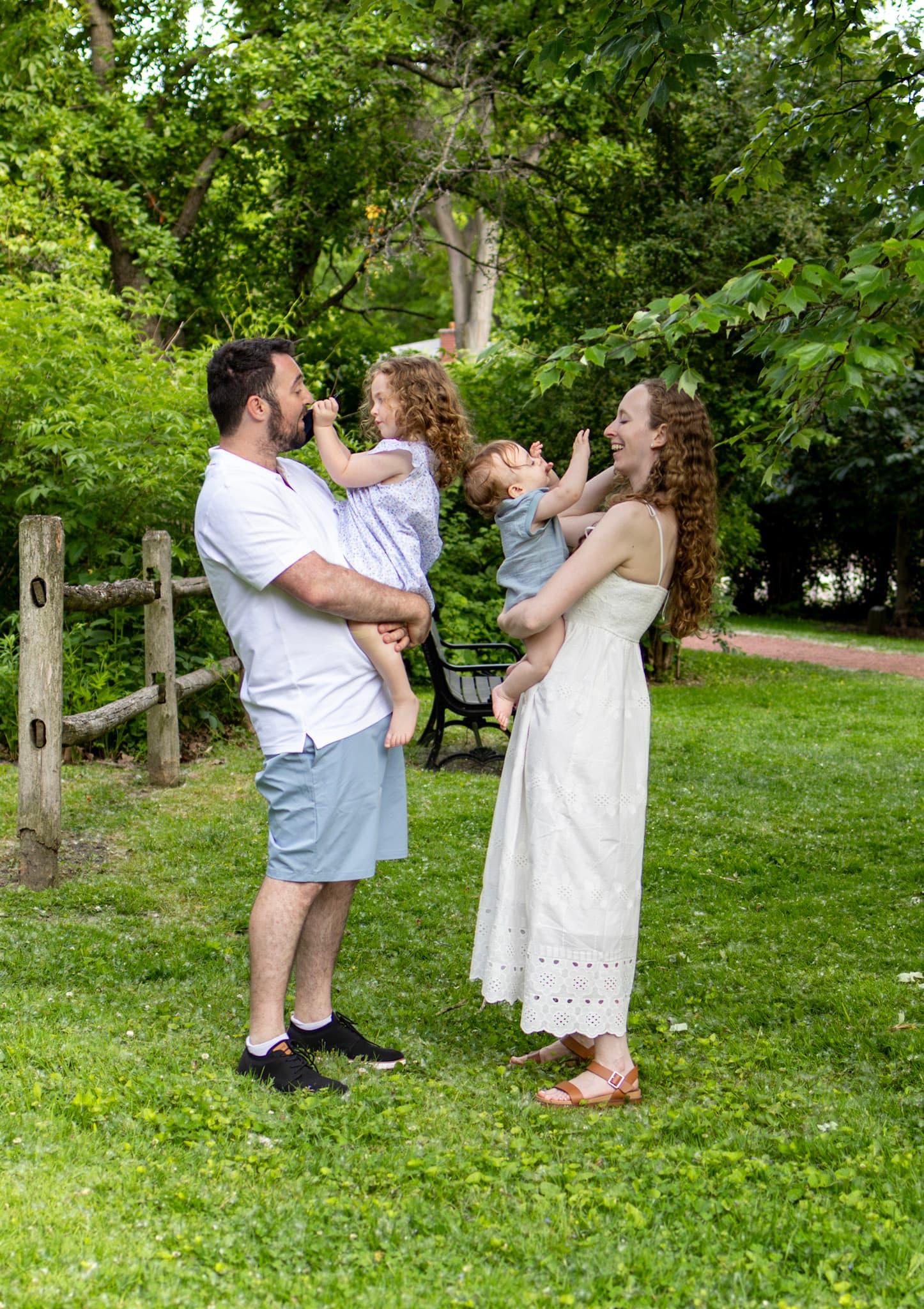 Playful family of four by a wooden split rail fence at Keay Nature Learning Center in Wilmette