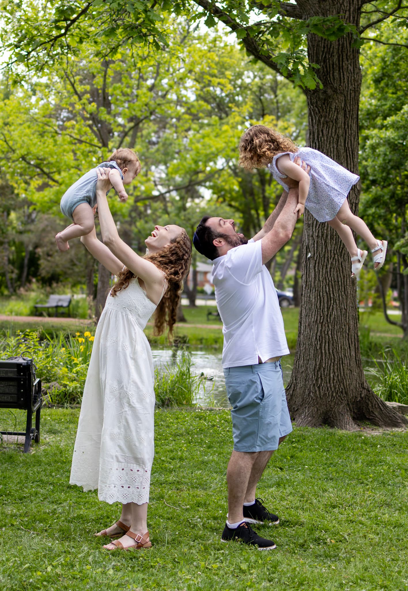 Parents lifting toddler son and daughter into the air during a joyful Keay Nature Center family session in Wilmette