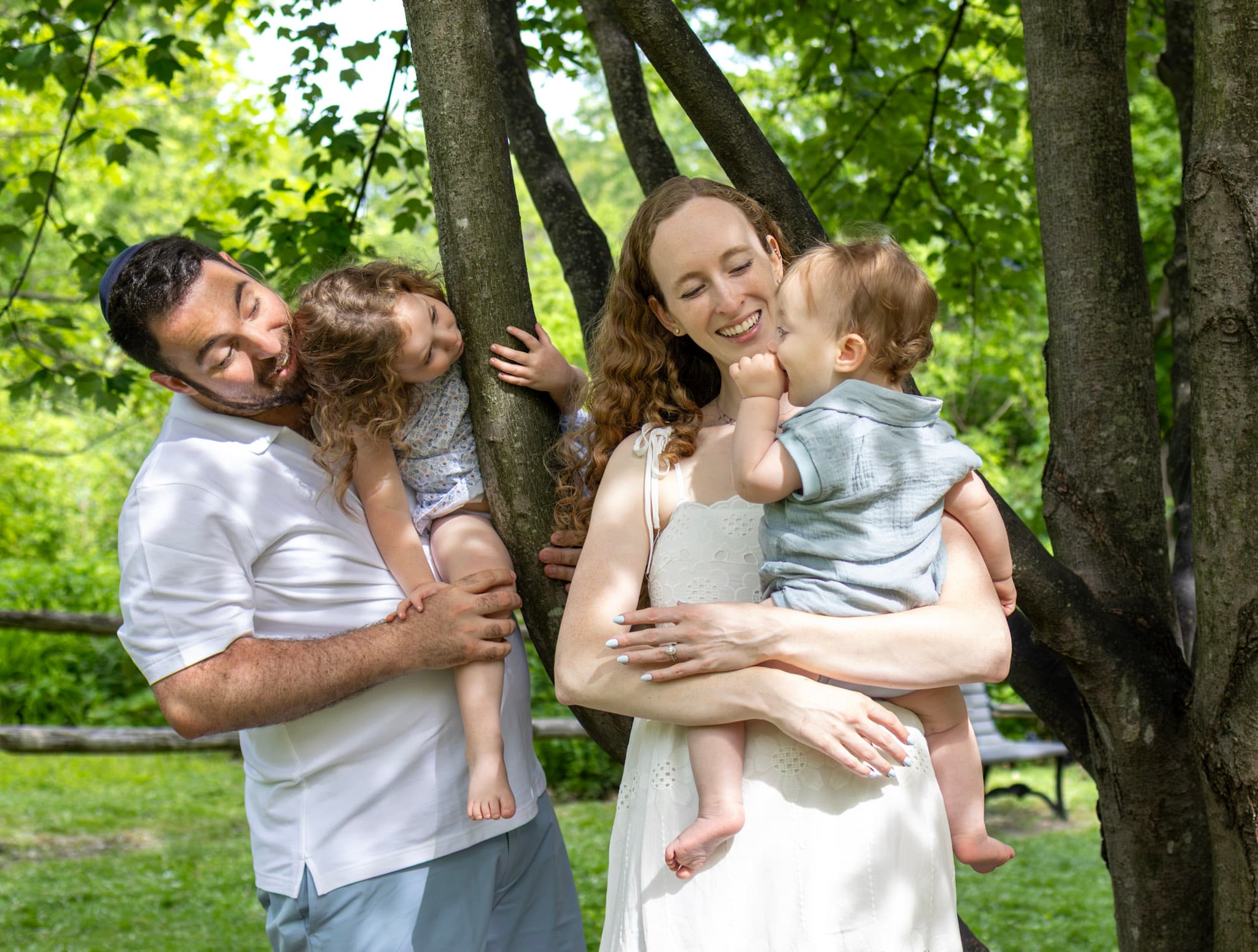 Parents holding their two kids beside a young tree at Keay Nature Learning Center in Wilmette