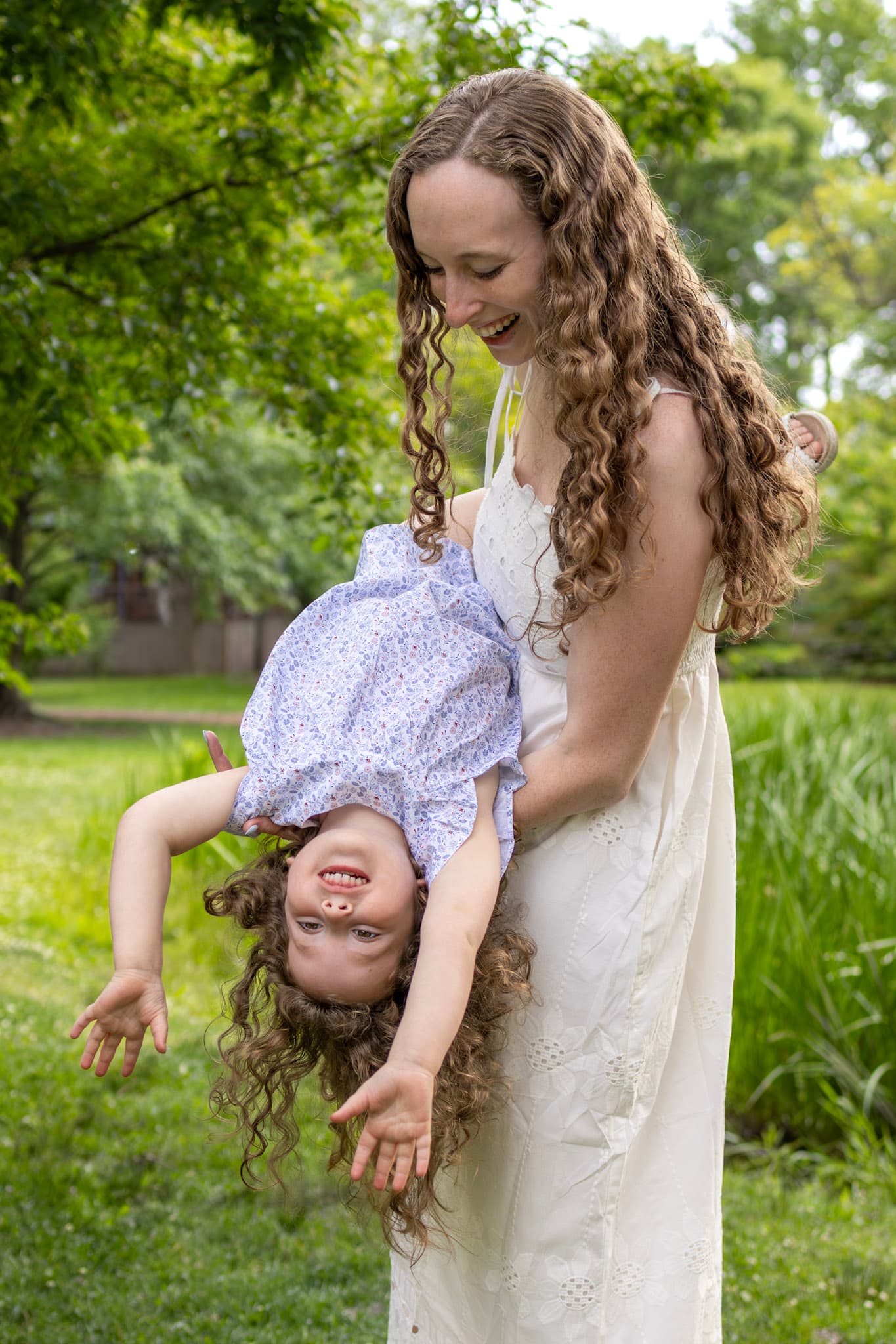 Mom holding daughter upside down in a playful candid moment during a Wilmette family photo session