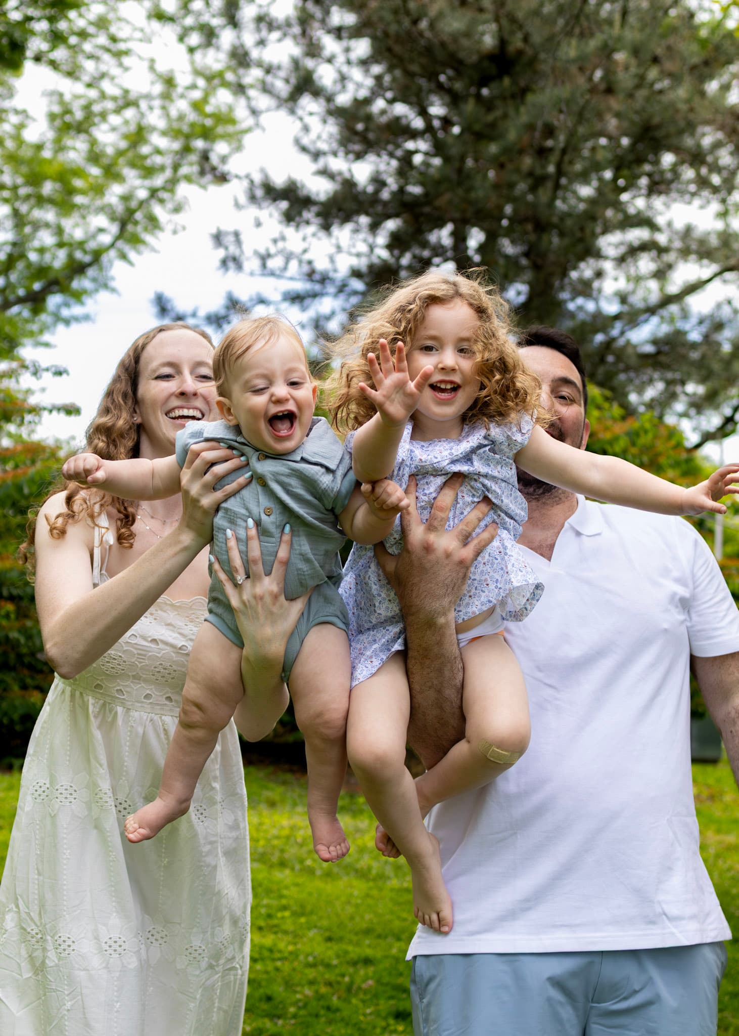 Mom in eyelet dress smiling while hugging toddler son during a Keay Nature Center family session in Wilmette
