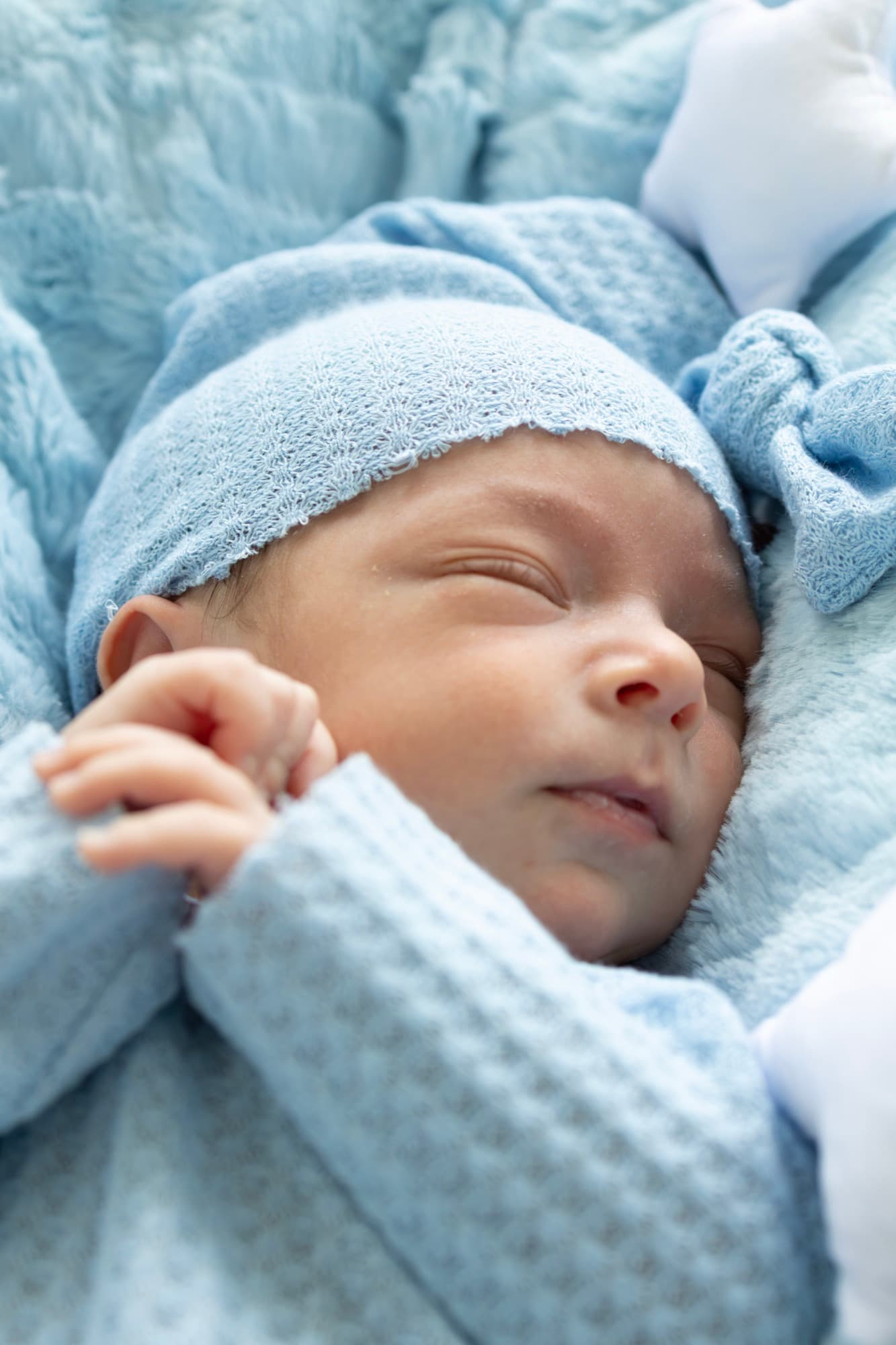 Newborn baby sleeping in blue knit outfit — peaceful baby portrait