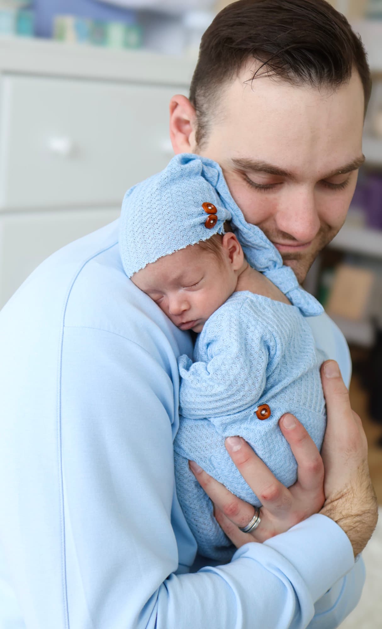 Father cradling sleeping newborn — dad and baby portrait