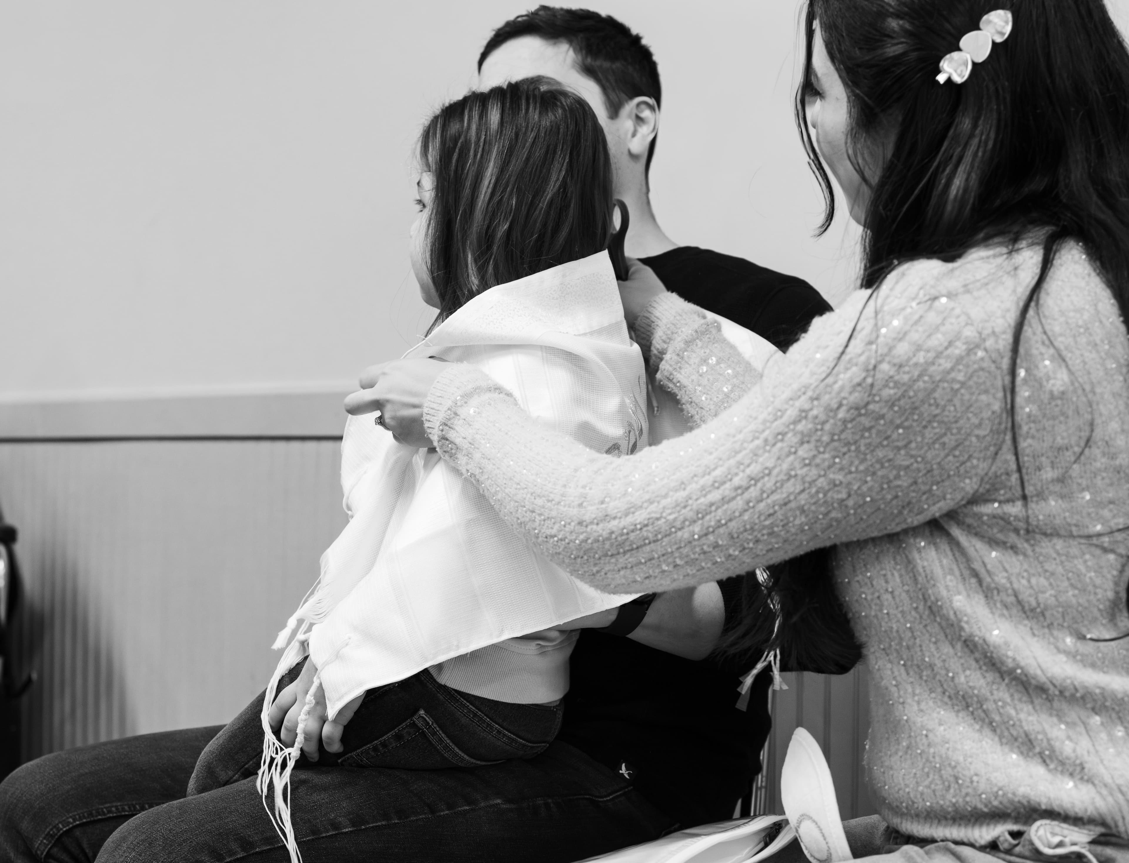 Family embracing during Upshirin ceremony in black and white — first haircut tradition