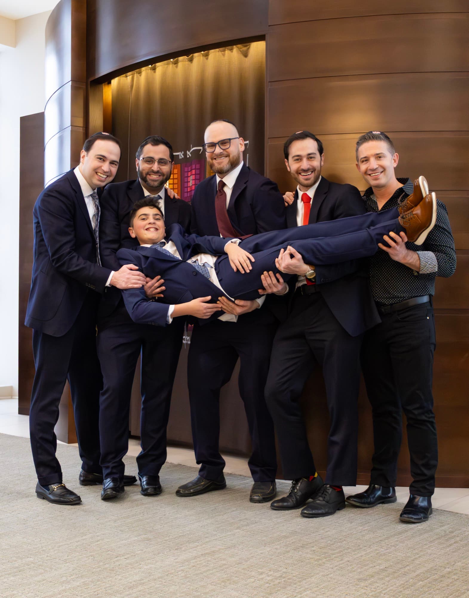 Guests lifting the Bar Mitzvah boy in celebration — joyful Bar Mitzvah moment