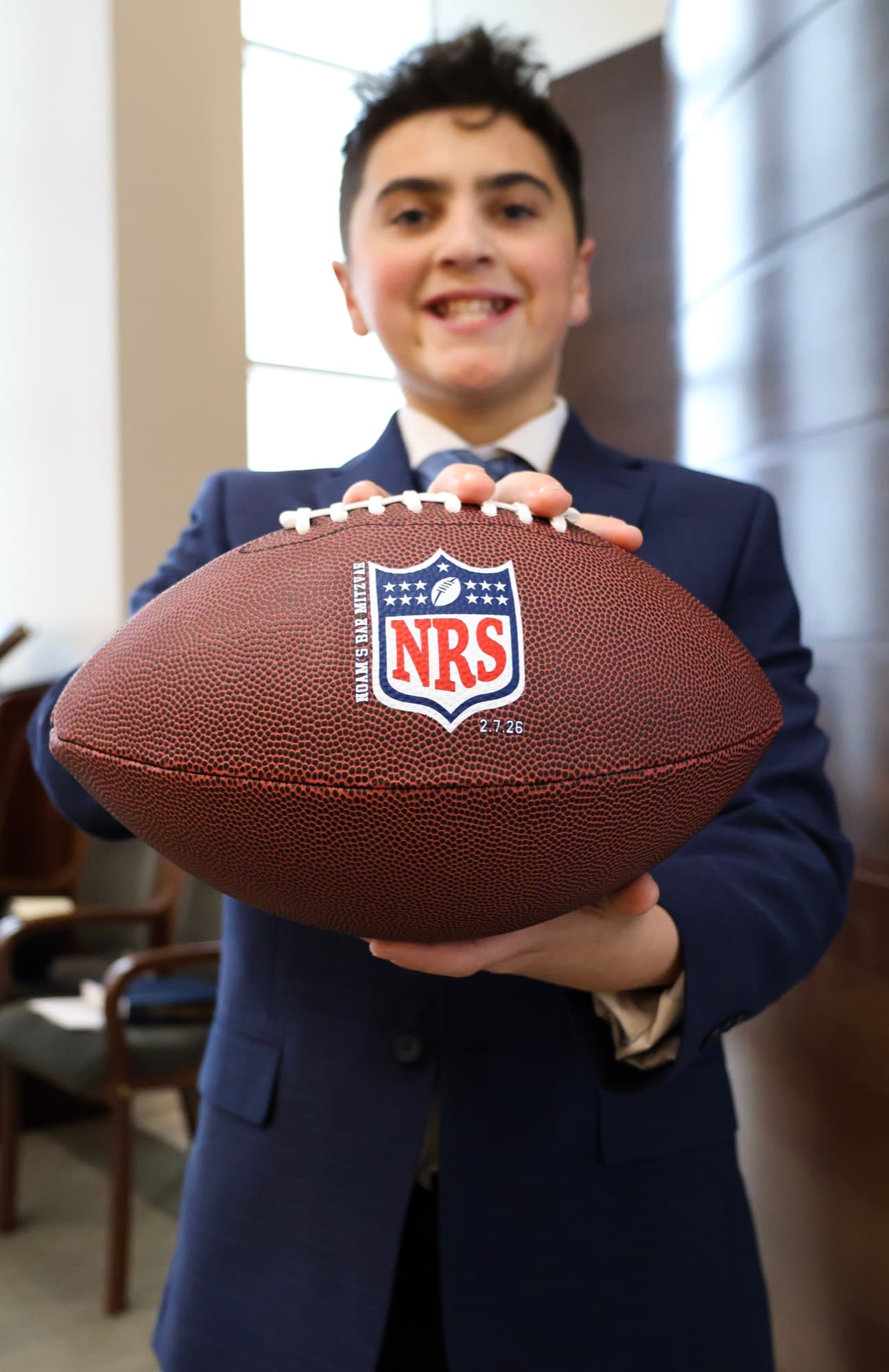 Bar Mitzvah boy holding custom football — personalized event detail