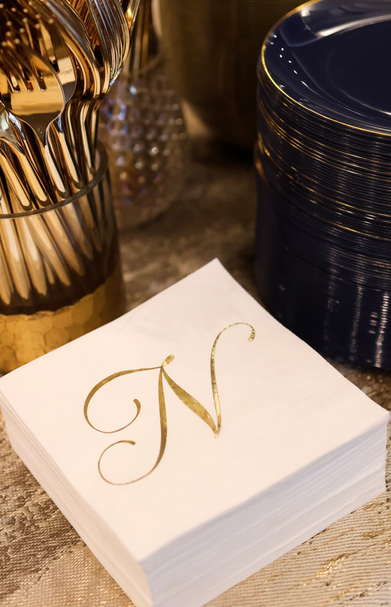Monogrammed napkins and navy gold table setting — elegant event décor