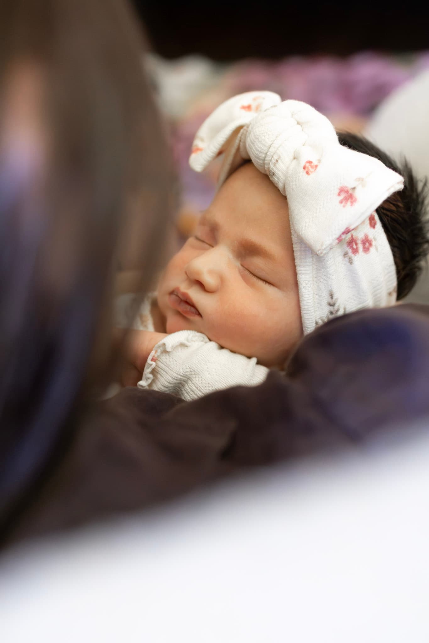 Newborn baby girl close-up with floral bow headband during a Skokie newborn session