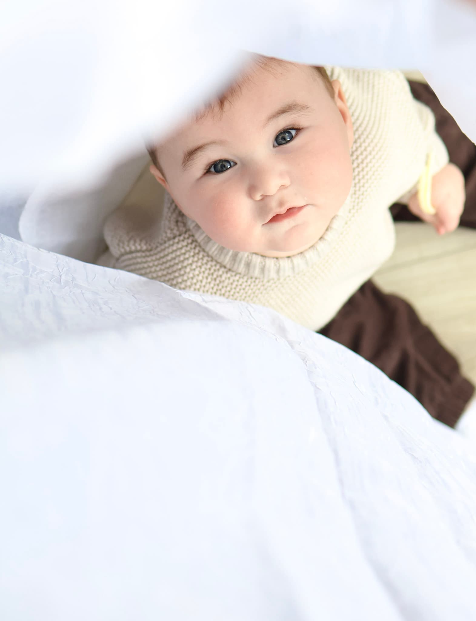 Parent holding 9 month old baby during a lifestyle family photo session at home