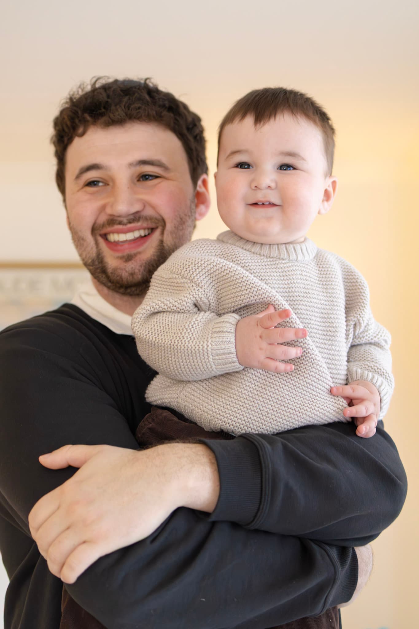 Father holding smiling baby for a natural light family portrait in West Rogers Park Chicago